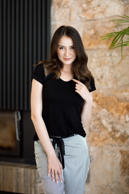 Femme portant un pyjama 2 pièces avec t-shirt noir dentelle et pantalon rayé noir et blanc