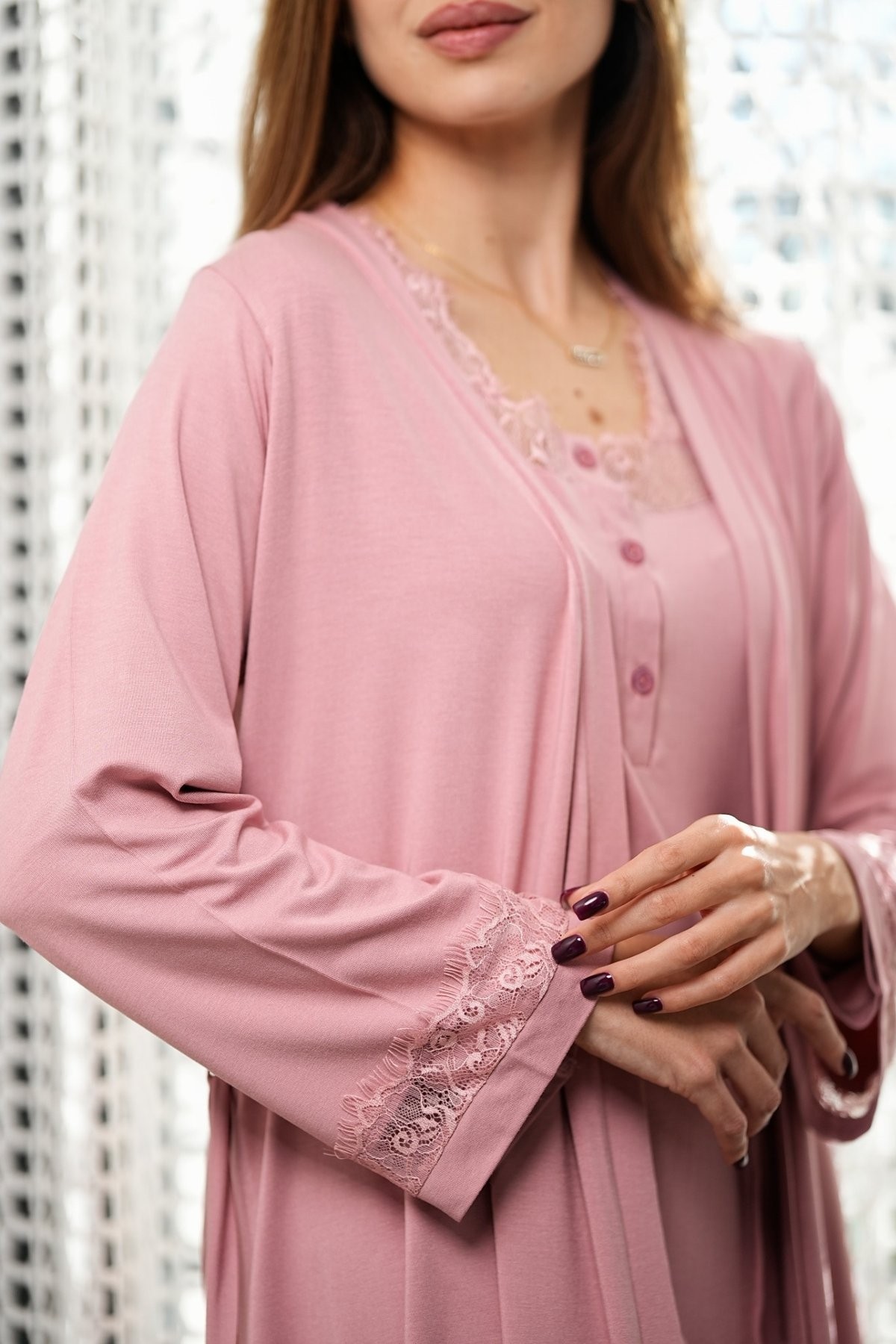 Gros plan sur les manches en dentelle du kimono maternité rose Glossy Envy.