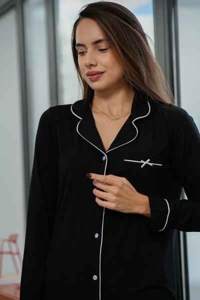 Gros plan sur la chemise de pyjama boyfriend noire avec bordure blanche et petite poche Glossy Envy.